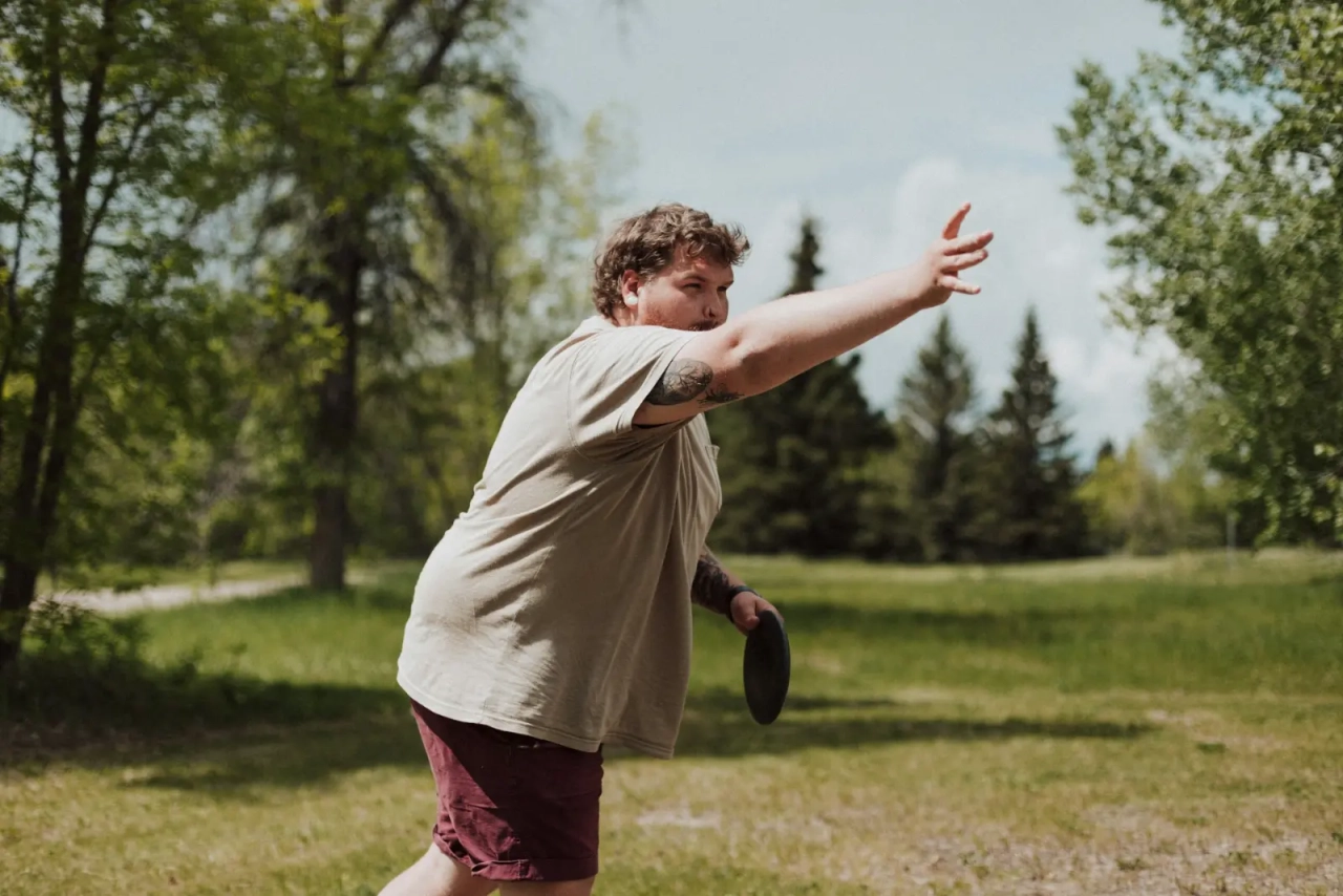 An overweight person exercising outside.