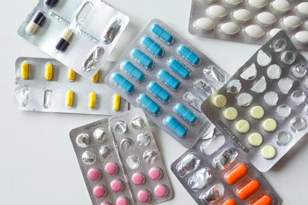 A collection of different pill capsules on a white surface.