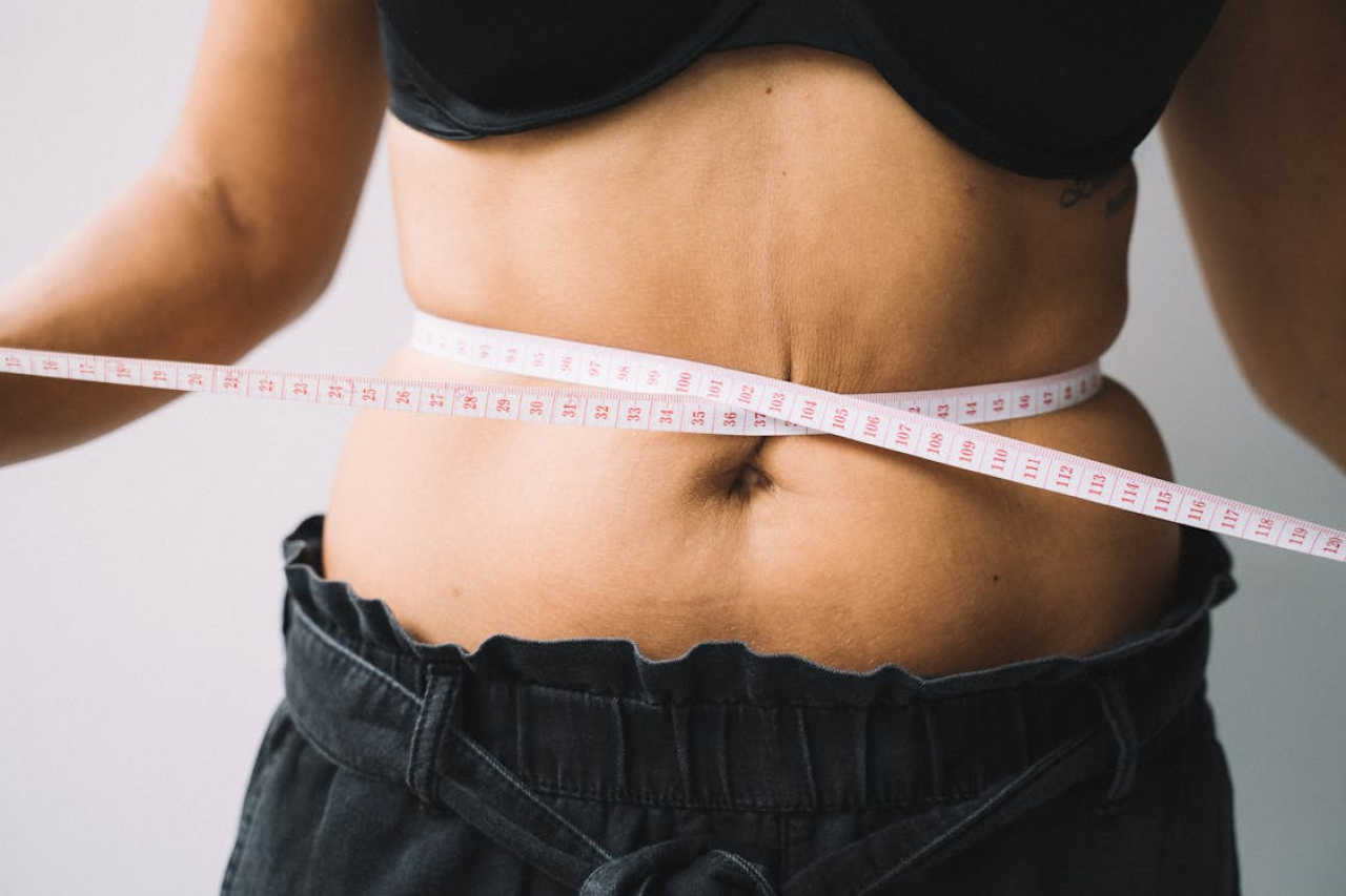 woman holding tape measure around waist.